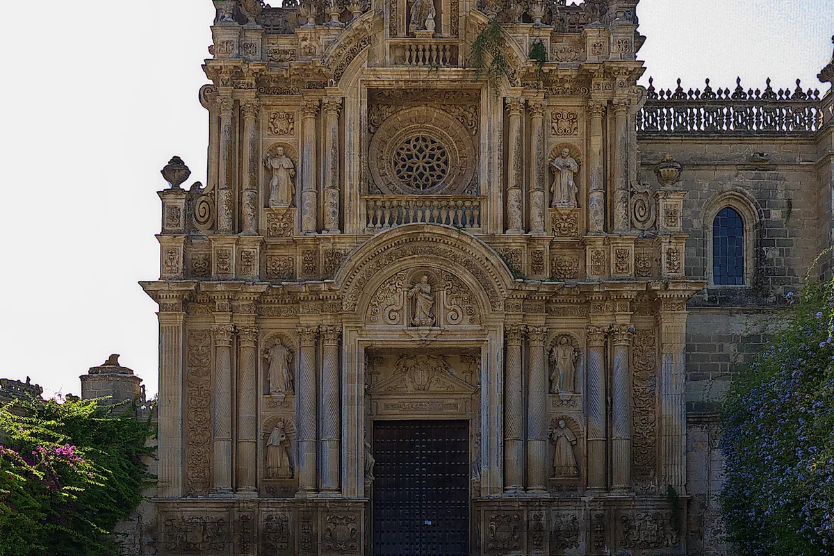 La portada de piedra tallada de la Cartuja de Jerez, con columnas, estatuas en hornacinas y un frontón redondeado